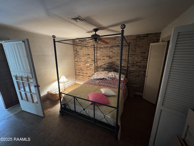bedroom with brick wall, visible vents, and tile patterned floors