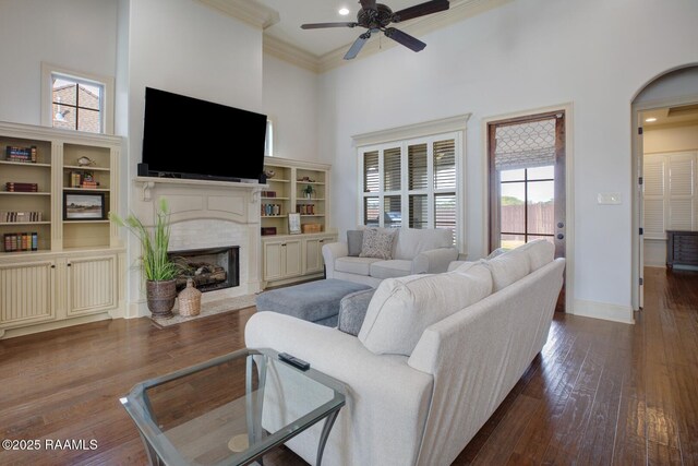 106 Rue De Chambery, Broussard, LA 70518 - living room with a high ceiling, dark wood-style flooring, a ceiling fan, a fireplace, and crown molding