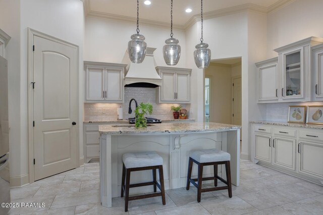 106 Rue De Chambery, Broussard, LA 70518 - kitchen featuring custom exhaust hood, a breakfast bar, light stone counters, and crown molding