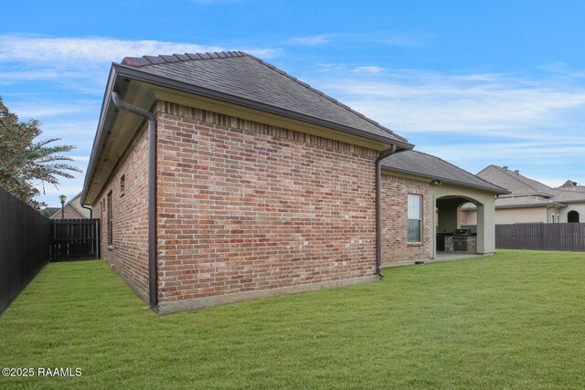 106 Rue De Chambery, Broussard, LA 70518 - view of side of property featuring a patio, a yard, a fenced backyard, and brick siding
