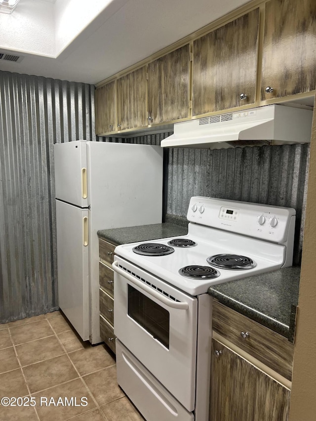 3121 Johnston St Unit 143, Lafayette, LA 70503 - kitchen with electric stove, under cabinet range hood, dark countertops, and light tile patterned flooring