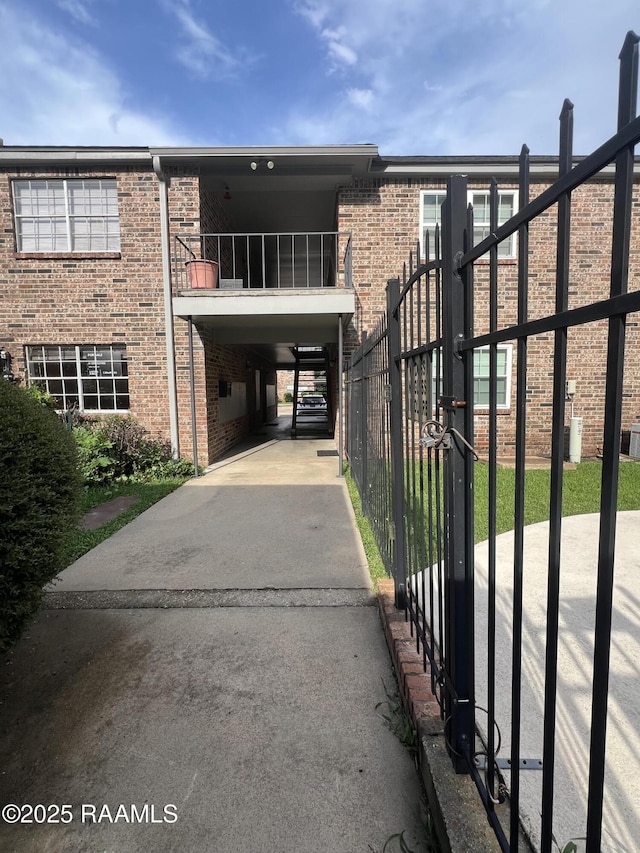 3121 Johnston St Unit 143, Lafayette, LA 70503 - view of front of property with a carport, brick siding, driveway, and a balcony