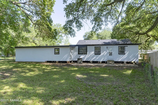 rear view of property featuring a yard, entry steps, central AC, and fence