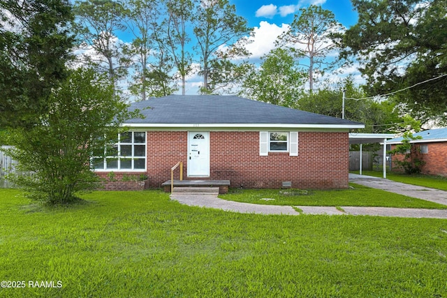 view of front of house featuring concrete driveway, a front yard, brick siding, and a carport