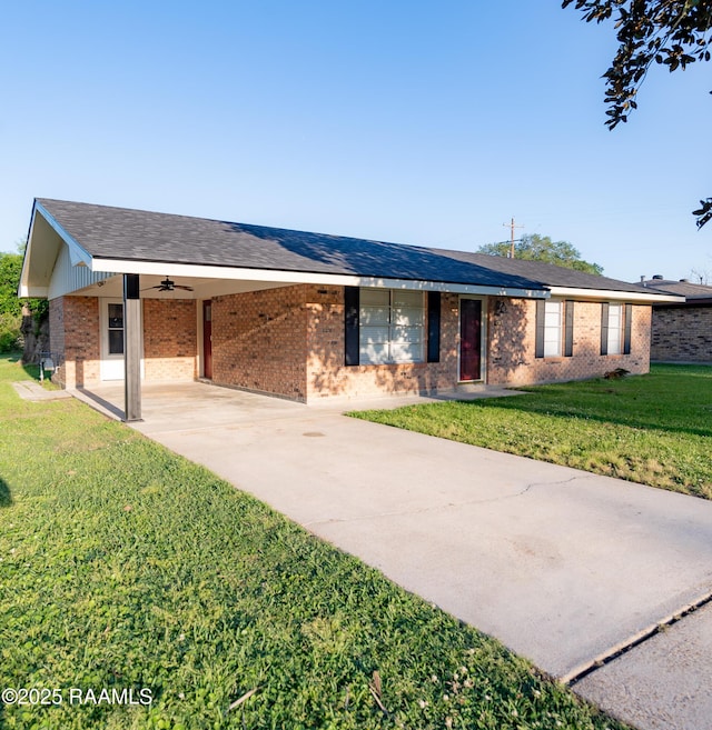 ranch-style house with a ceiling fan, concrete driveway, brick siding, a front lawn, and an attached carport