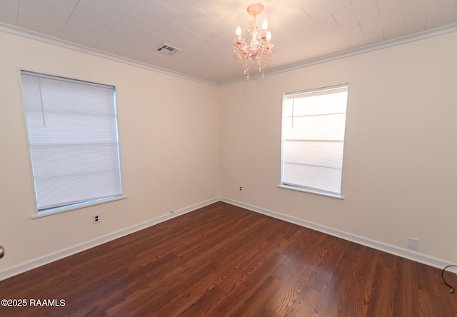 unfurnished room featuring a chandelier, baseboards, ornamental molding, and dark wood finished floors