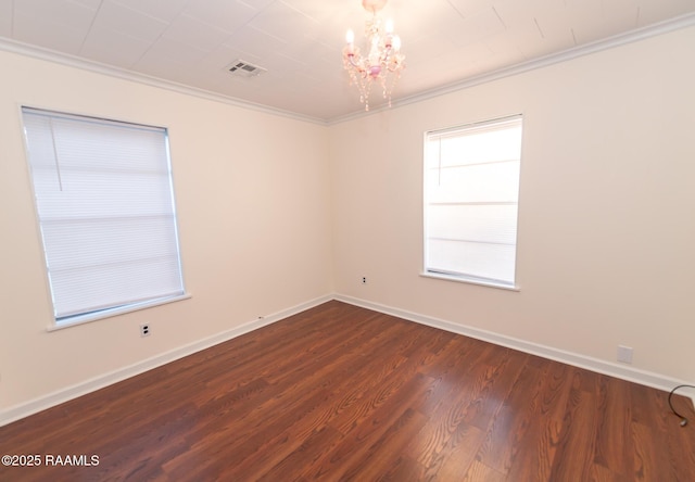 empty room with an inviting chandelier, visible vents, ornamental molding, and dark wood finished floors