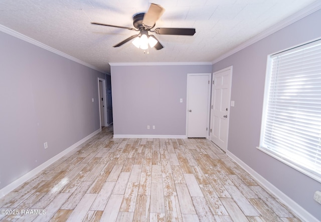 spare room with light wood finished floors, baseboards, crown molding, and ceiling fan