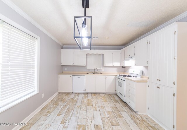 kitchen featuring under cabinet range hood, white appliances, light countertops, and a sink