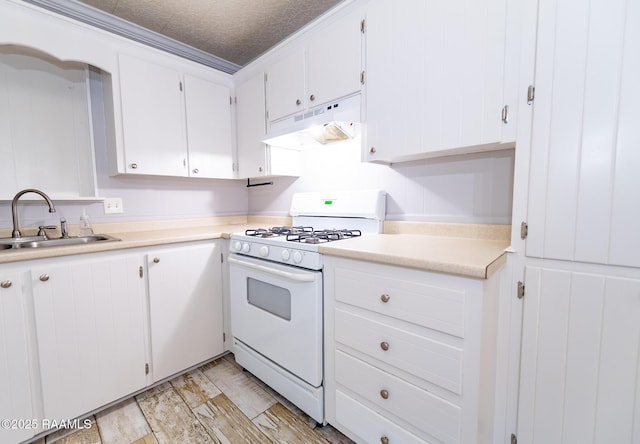 kitchen featuring white range with gas cooktop, white cabinets, under cabinet range hood, light countertops, and a sink