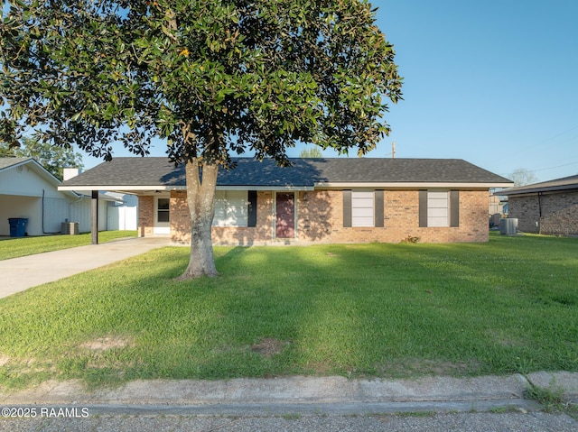 single story home with cooling unit, a front lawn, brick siding, concrete driveway, and an attached carport
