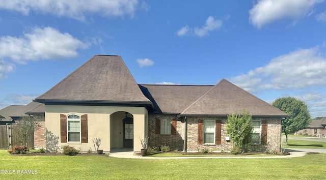 1010 Grand Loop, Breaux Bridge, LA 70517 - french country home with brick siding, roof with shingles, and a front yard