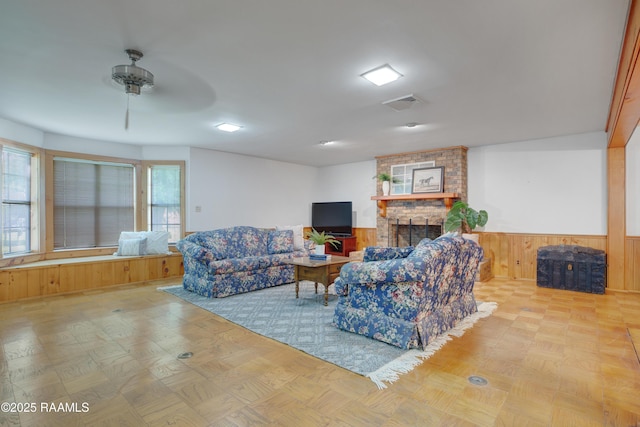 1119 Mary Lee St, Franklin, LA 70538 - living room featuring wooden walls, visible vents, wainscoting, and a stone fireplace