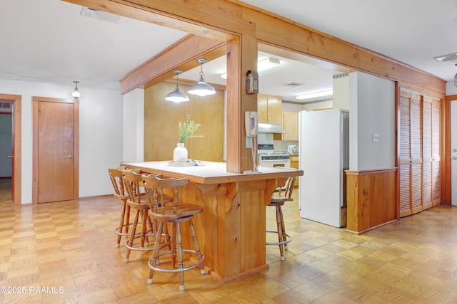 1119 Mary Lee St, Franklin, LA 70538 - kitchen featuring under cabinet range hood, white appliances, a breakfast bar, a peninsula, and light countertops