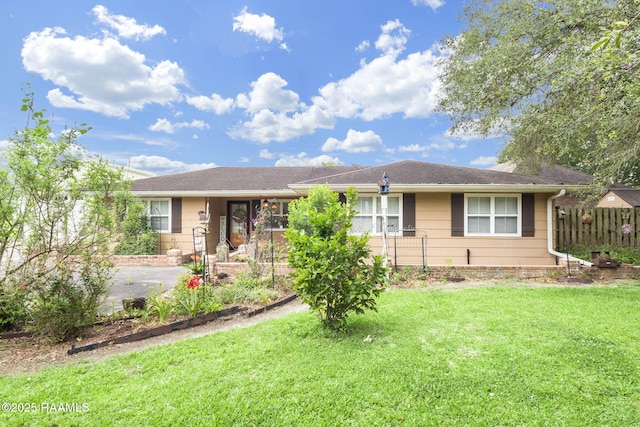 ranch-style house with fence and a front lawn