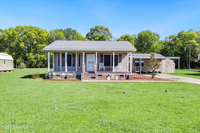 197 John Paul Dr, Opelousas, LA 70570 - view of front of house with driveway, a front yard, a porch, a storage shed, and an outbuilding