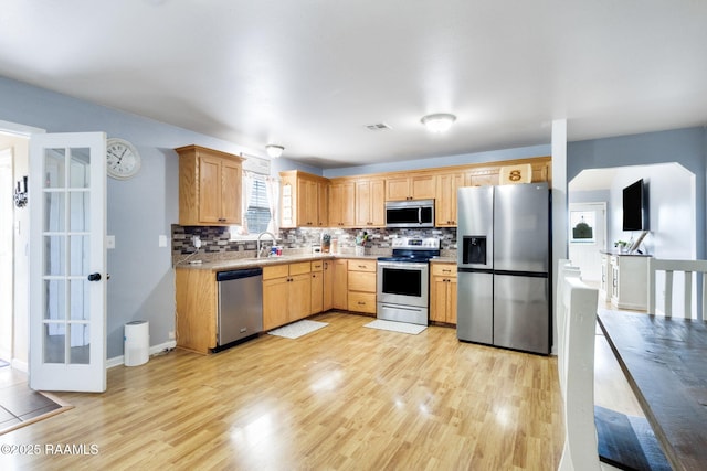 197 John Paul Dr, Opelousas, LA 70570 - kitchen with backsplash, visible vents, stainless steel appliances, light wood finished floors, and a sink