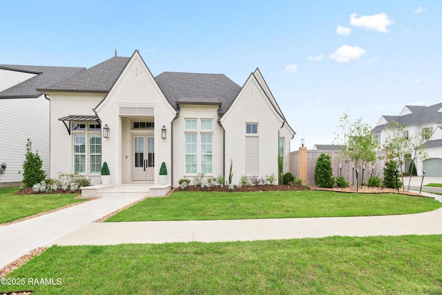 211 Crossbill Dr, Lafayette, LA 70508 - french country style house with brick siding, roof with shingles, fence, and a front yard