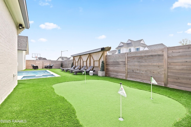 211 Crossbill Dr, Lafayette, LA 70508 - view of yard with a storage unit, a pool with connected hot tub, an outbuilding, and a fenced backyard