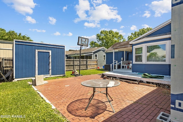 view of patio featuring an outbuilding, fence, and a storage shed