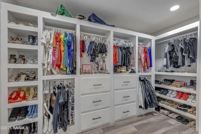 walk in closet with light wood-style floors