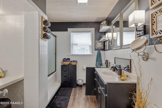 bathroom featuring tile walls, vanity, and wood finished floors
