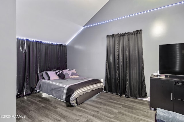 bedroom with vaulted ceiling and wood finished floors