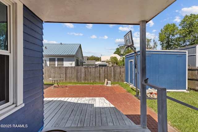wooden terrace with a shed, a fenced backyard, and an outdoor structure