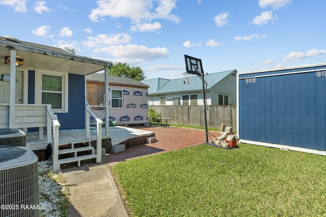 view of yard featuring fence and central AC