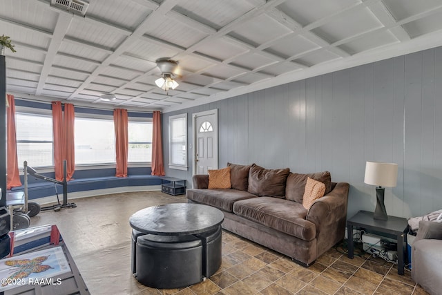 living room with visible vents, ceiling fan, coffered ceiling, and wood walls