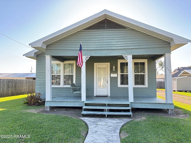 view of front facade with a porch, fence, and a front yard