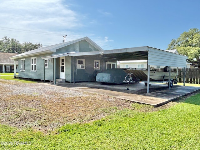 rear view of house featuring a yard, fence, entry steps, and an attached carport