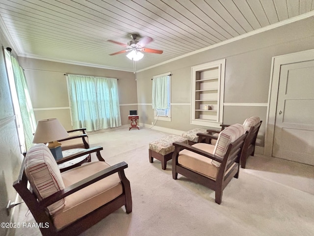 sitting room with ornamental molding, ceiling fan, carpet flooring, and wooden ceiling