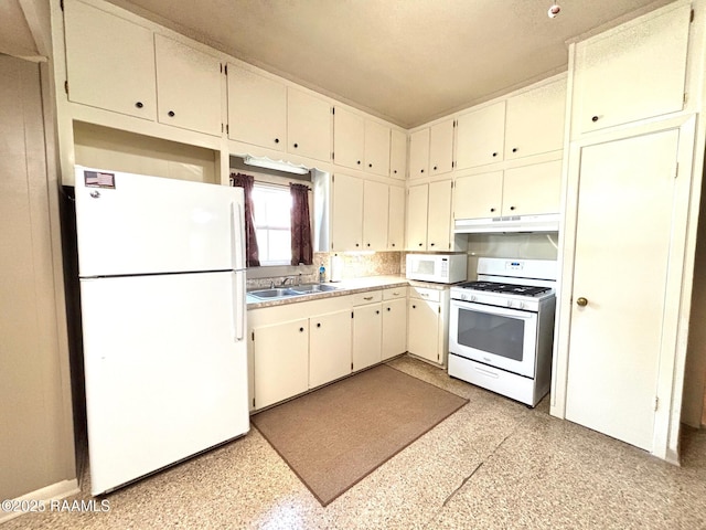 kitchen featuring a sink, under cabinet range hood, white appliances, and light countertops