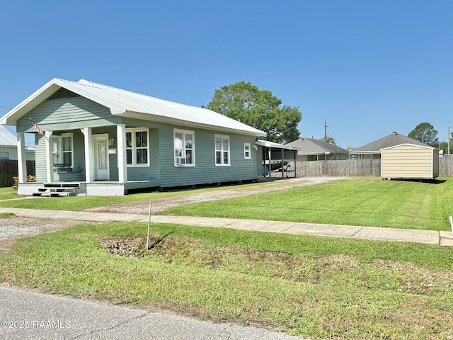 view of front facade featuring covered porch, fence, and a front yard