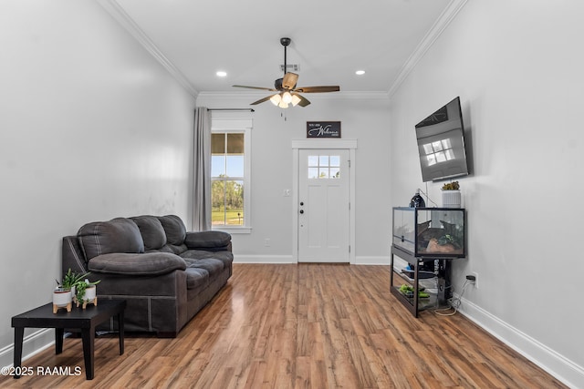 living room featuring visible vents, baseboards, ceiling fan, crown molding, and wood finished floors