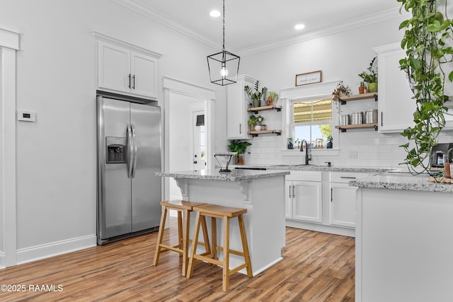 kitchen featuring stainless steel fridge with ice dispenser, open shelves, light wood-style floors, white cabinetry, and decorative backsplash