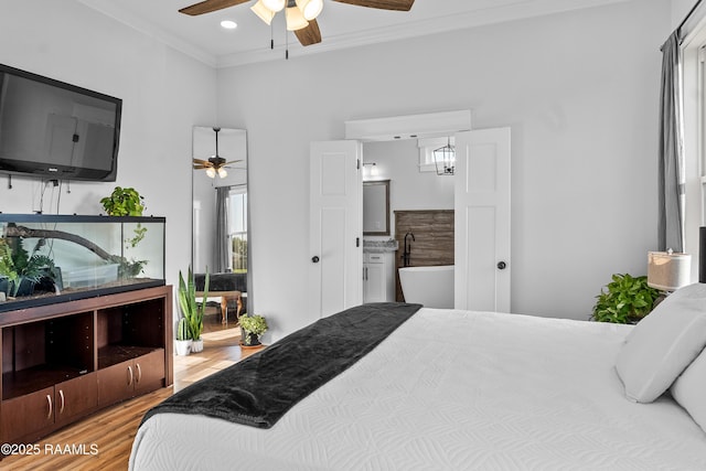 bedroom featuring recessed lighting, ensuite bath, crown molding, ceiling fan, and light wood finished floors