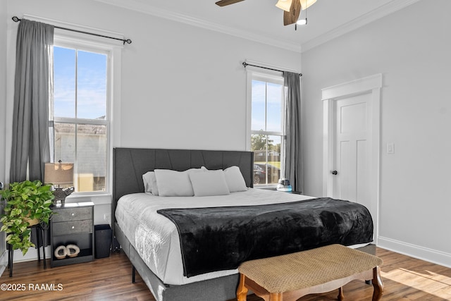 bedroom featuring ceiling fan, baseboards, crown molding, and wood finished floors