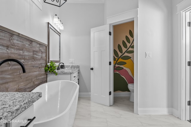 bathroom with vanity, marble finish floor, baseboards, and a soaking tub