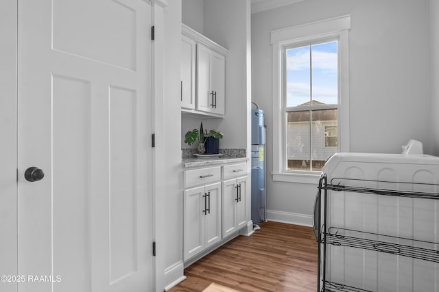 interior space featuring wood finished floors, baseboards, and ornamental molding