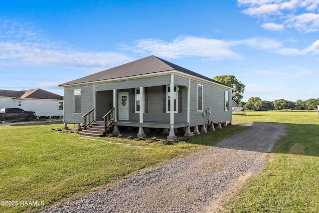 view of front of property with roof with shingles, driveway, a front lawn, and covered porch