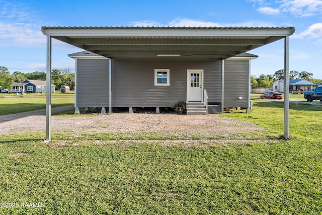 rear view of house with entry steps and a lawn