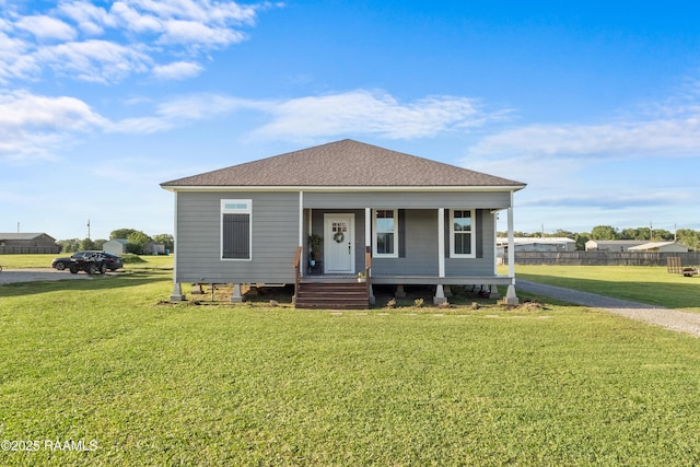bungalow-style home featuring a shingled roof, fence, and a front lawn