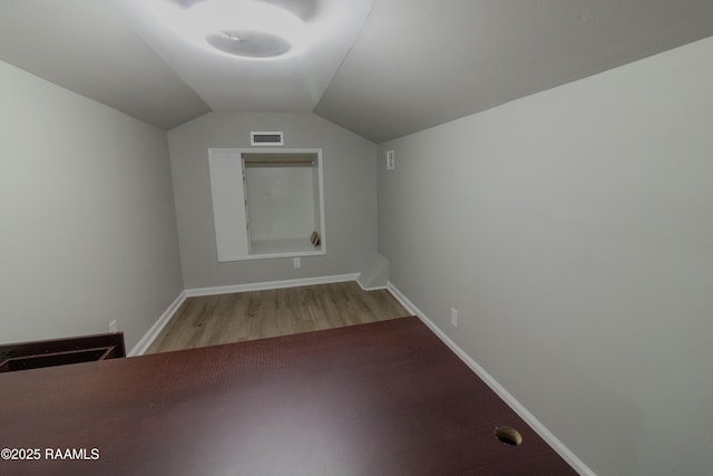bonus room with visible vents, light wood-type flooring, baseboards, and lofted ceiling