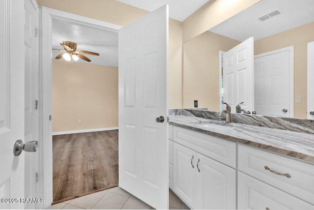 7848 Lake St, Lake Charles, LA 70605 - bathroom with ceiling fan, vanity, visible vents, wood finished floors, and baseboards