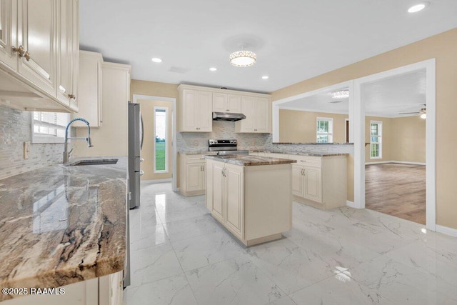 7848 Lake St, Lake Charles, LA 70605 - kitchen featuring baseboards, backsplash, under cabinet range hood, appliances with stainless steel finishes, and a sink