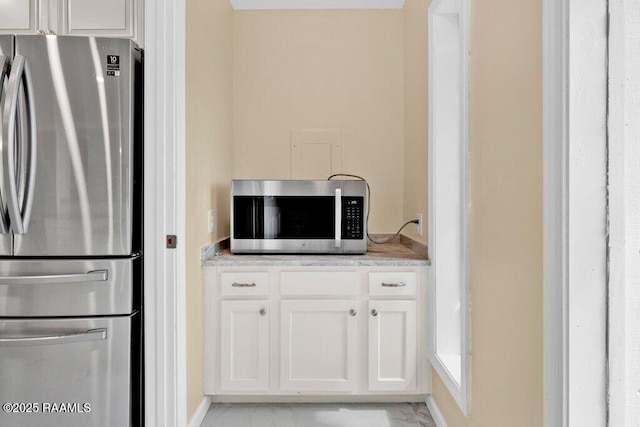 7848 Lake St, Lake Charles, LA 70605 - kitchen featuring stainless steel appliances, white cabinets, marble finish floor, and baseboards