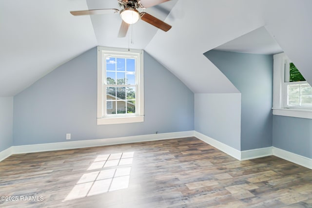 bonus room with wood finished floors, baseboards, a wealth of natural light, and ceiling fan