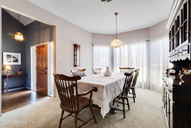dining room with a notable chandelier, light colored carpet, and a healthy amount of sunlight
